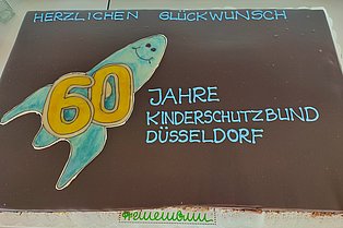 Torte mit Schokoladenüberzug und Aufschrift 60 Jahre Kinderschutzbund Düsseldorf